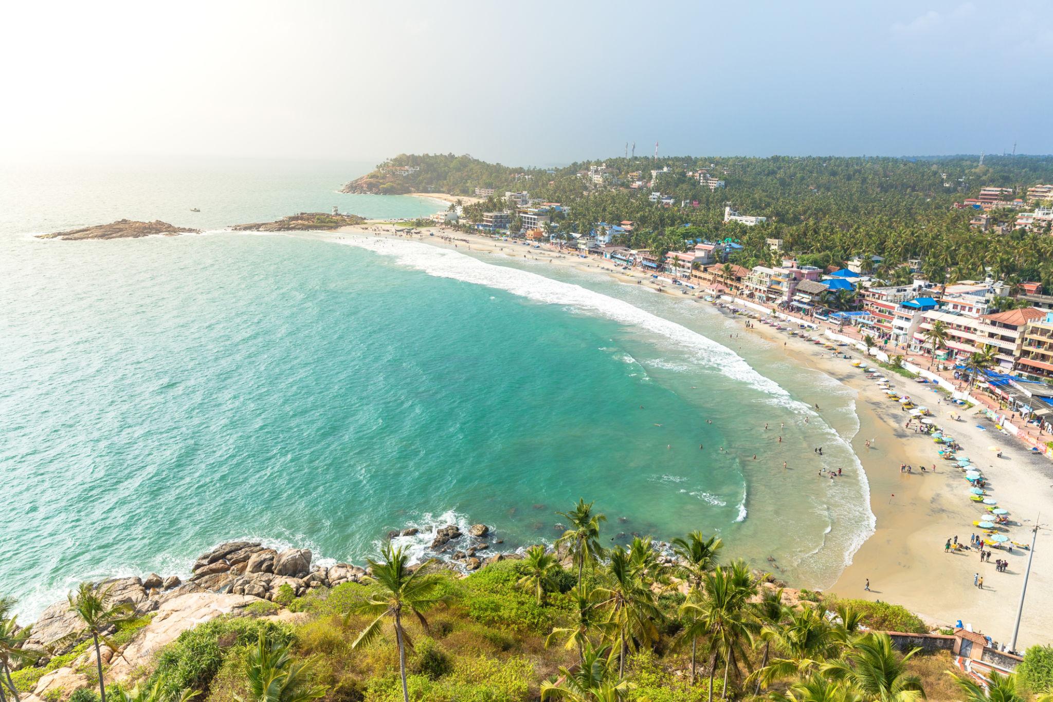Scenic Kovalam beach with palm trees and waves